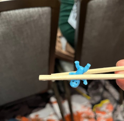 Plastic baby between chopsticks